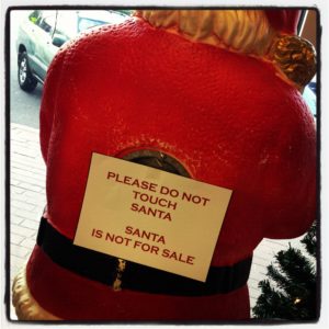 santa lawn ornament with sign saying "do not touch"
