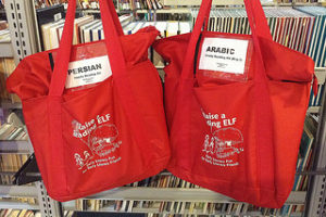 Two red bags containing books, one labeled "Persian" and one labeled "Arabic"