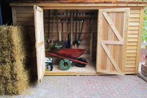 a red wheelbarrow inside a gardening shed