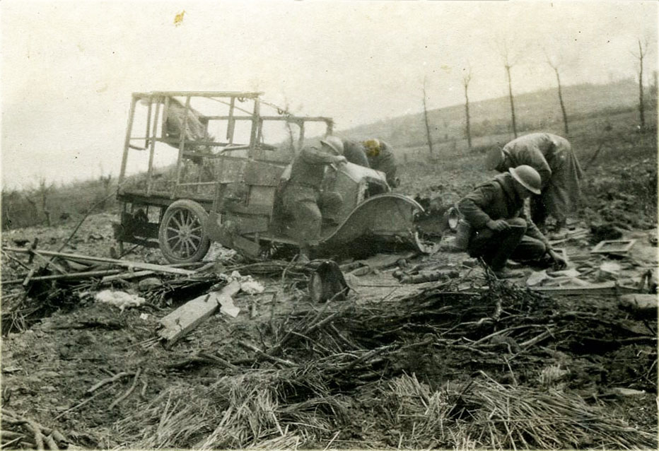World War I photo of a car hit by a shell, with 3 soldiers. June 1918.