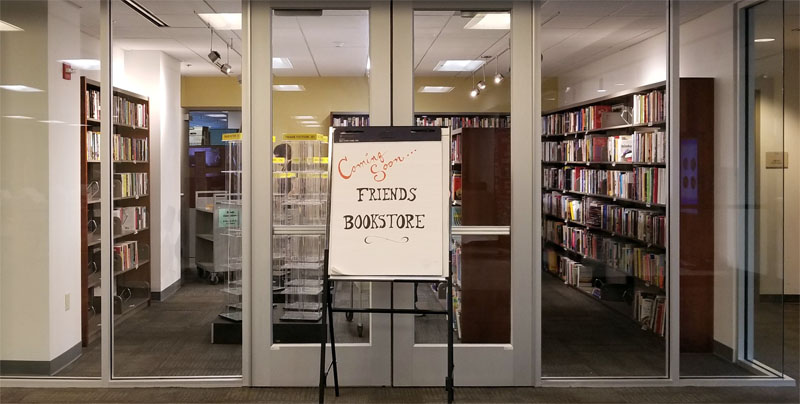 Photo of the new Friends bookstore half stocked, with a "Coming Soon" sign outside