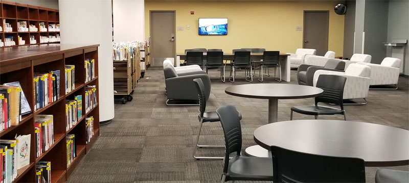 Comfy chairs and study tables in the alcove, and hold shelves on the left