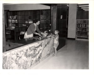 Central Library Reference Desk, early 1960s, librarians speaks to young child