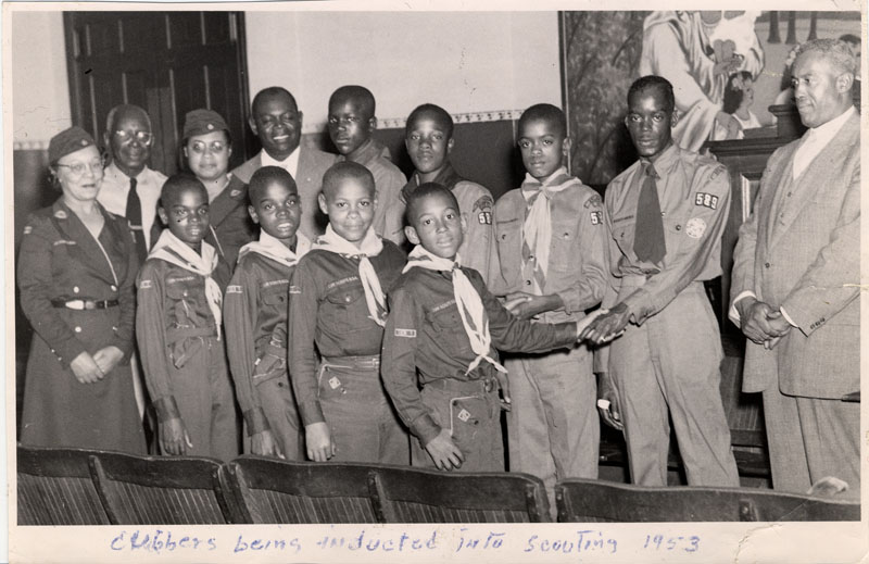 black and white photo of group of young african american boys in cub scout uniforms with pack leaders