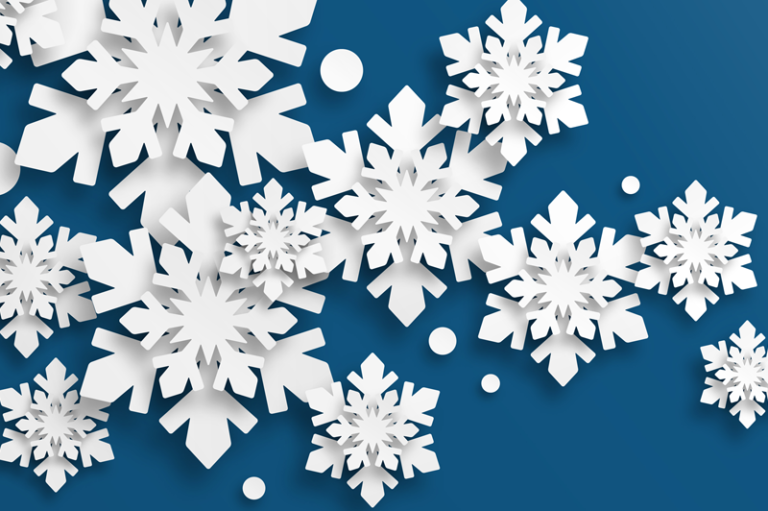 Cut paper snowflakes on blue background