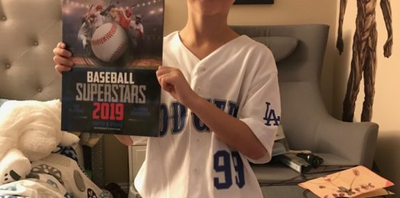 Dressed as a Los Angeles Dodgers baseball player reading a book about Baseball Superstars.