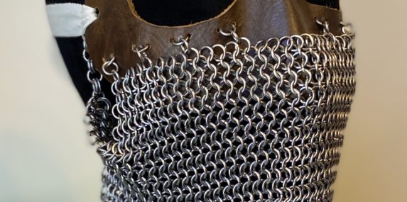 Stainless steel European 4-in-1 chain weave; wet-molded leather; cotton. I have been making chainmaille and scale maille pieces for roughly eight years. This is not the greatest skill to have when making masks to combat viral infections. Nevertheless, I Googled "chainmaille mask" to see what was out there, and I was immediately struck by World War One-era tank masks. These masks were worn by tank gunners to protect their faces against schrapnel. They are heavy and strong and yet vulnerable to other dangers of war, such as poisonous gas and infection. I knew I immediately had to make one of these masks to manifest some of my pandemic emotions.