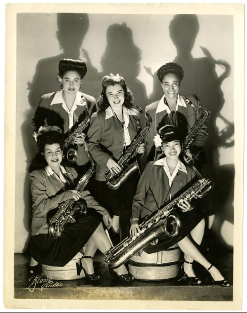 Five women hold saxaphones and smile.