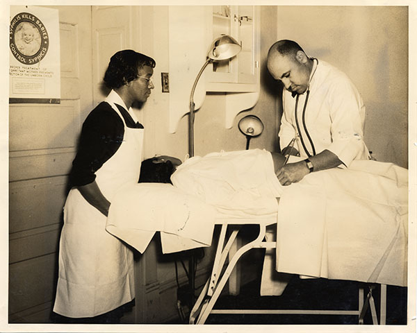 Dr. Bruner examines a patient while a nurse assists.