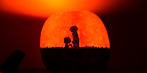 The "stars" were made using 3 different sized nails inserted at various angles, so their luminosity changes depending on your viewing angle. So if you walk around the pumpkin, it "twinkles". Also, Hobbes' orange fur is the skin of the pumpkin.