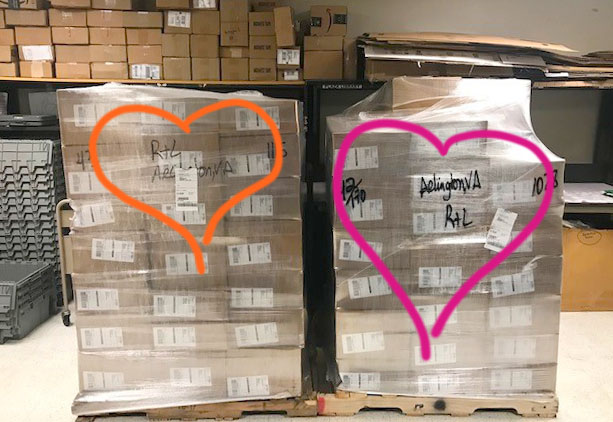 Photo of two huge pallets of books, with hearts drawn on top.