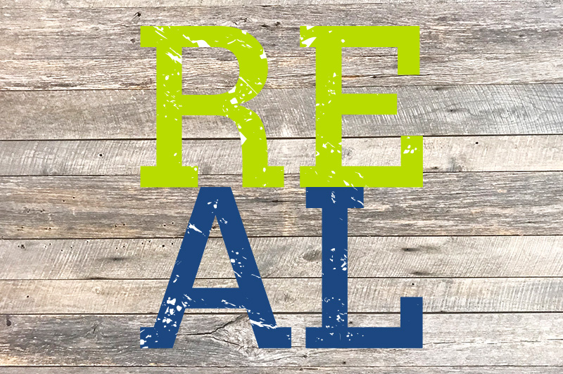 Green-blue letters displaying REAL set against a wooden texture.