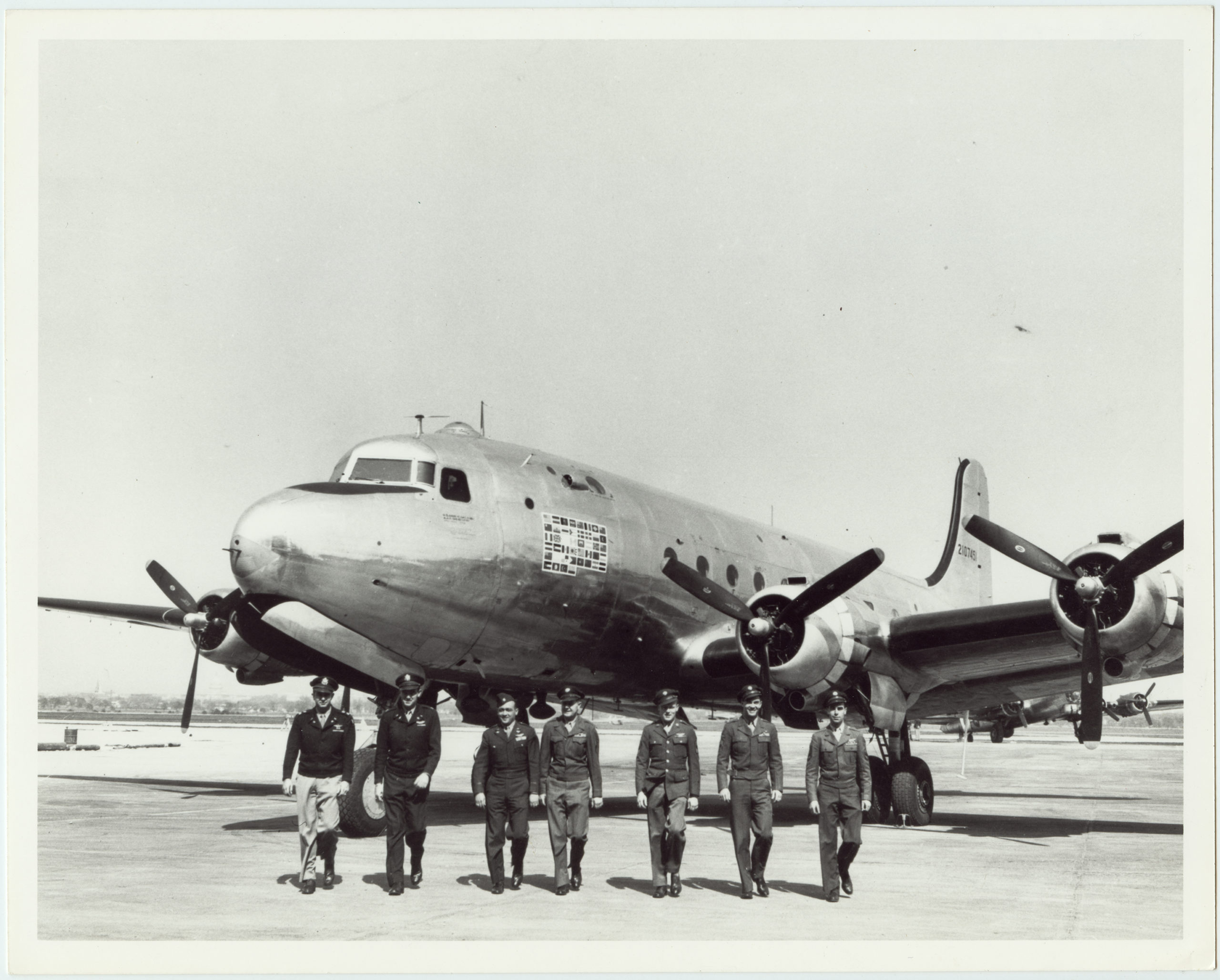 Reproduction image of a National Archives print that reads: A full view of the four-motored Douglas C-54 skymaster dubbed the 'Flying White House', an ATC transport specially built for President Roosevelt.  It has flown over 44 countries and established six world records since it was put into service exactly a year ago [1944].  Seven pilots are seen walking in front of the plane. 1945, 1 print, b&amp;w, 8 x 10 in..