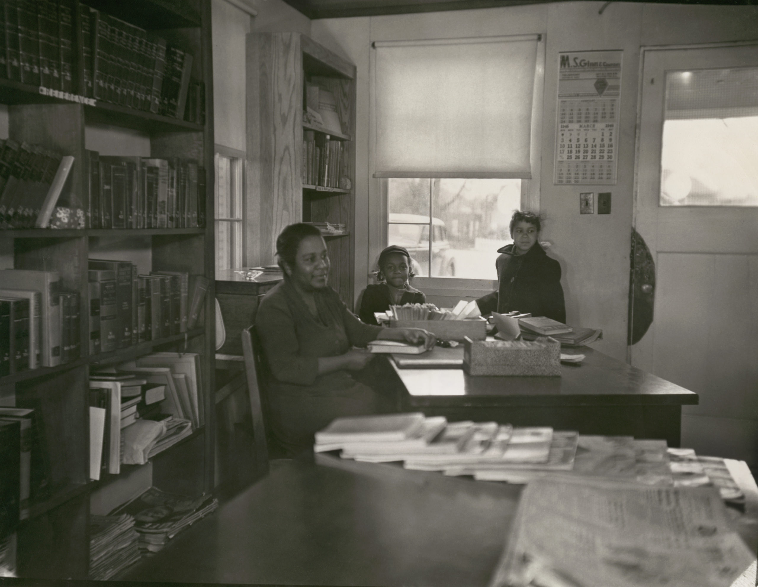 A librarian and two children inside the Holmes Branch of the Arlington Public Library 1946, 1 print, b&amp;w, 8 x 10 in..