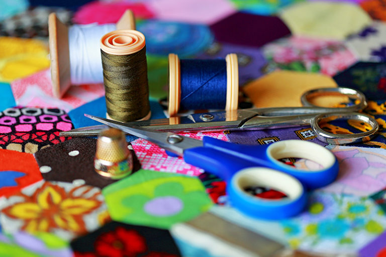 Photo of colorful fabric with a pair of scissors.