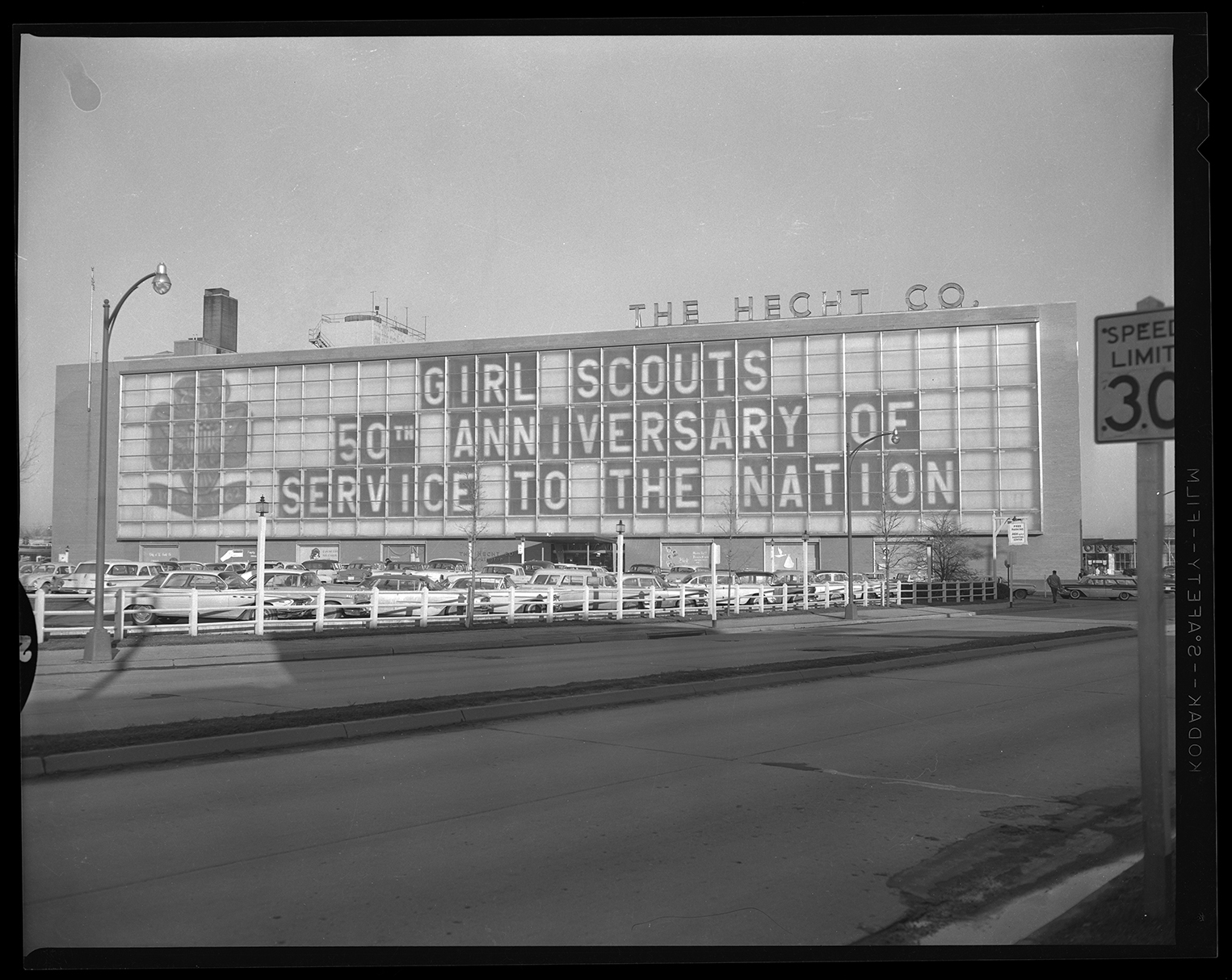 The large Hecht's window with lettering that says Girl Scouts 50th Anniversary of Service to the Nation.