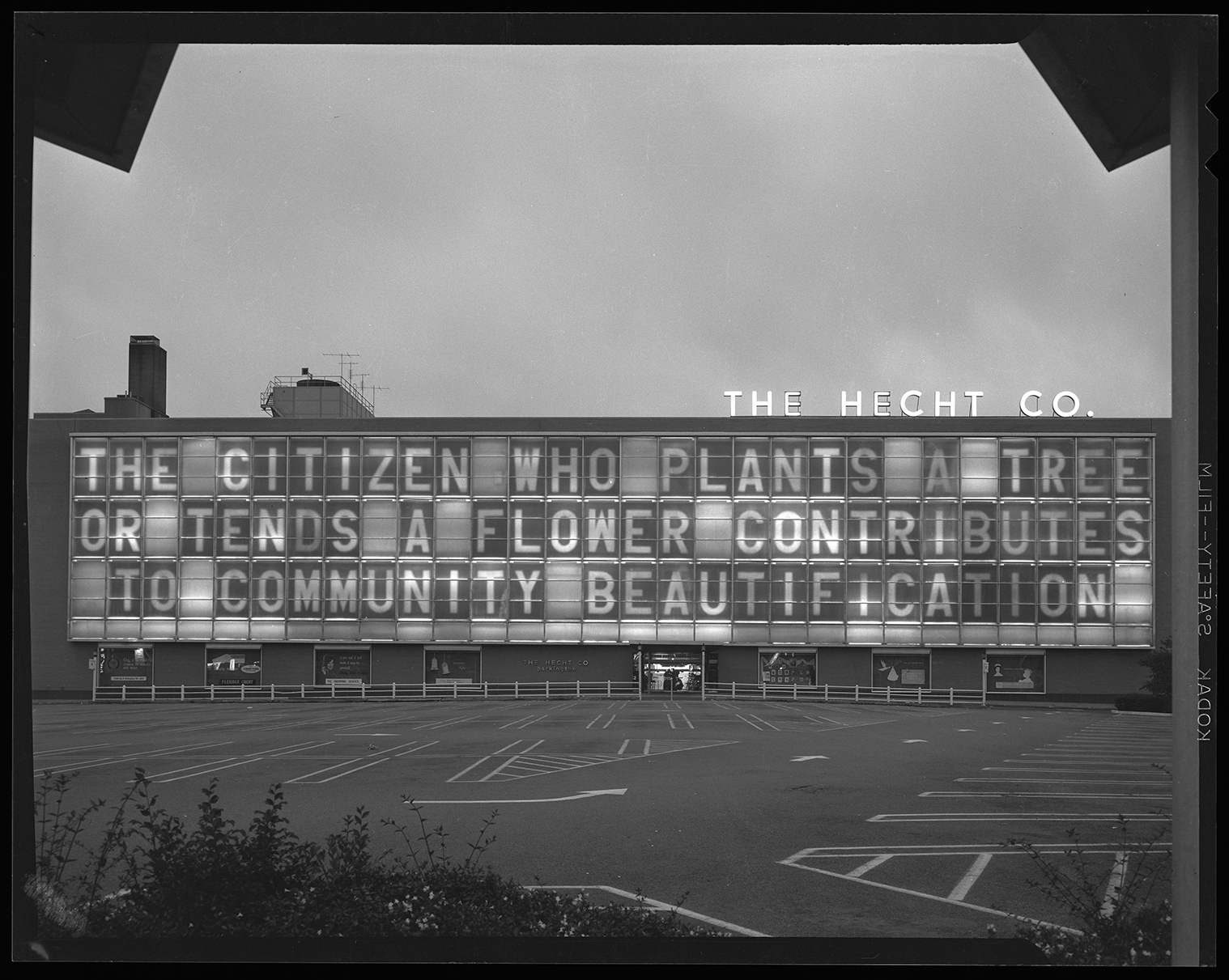 Evening shot of the large Hecht's window with lettering that says The citizen who plants a tree or tends a flower contributes to community beautification.