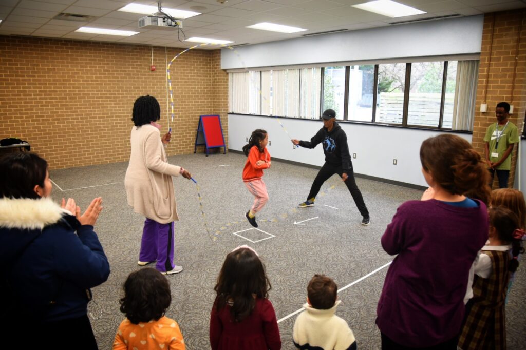 A child jumps double dutch in a children's event at Aurora Hills library.