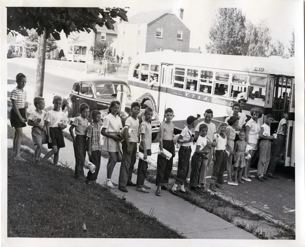Children lined up to board a school bus.
