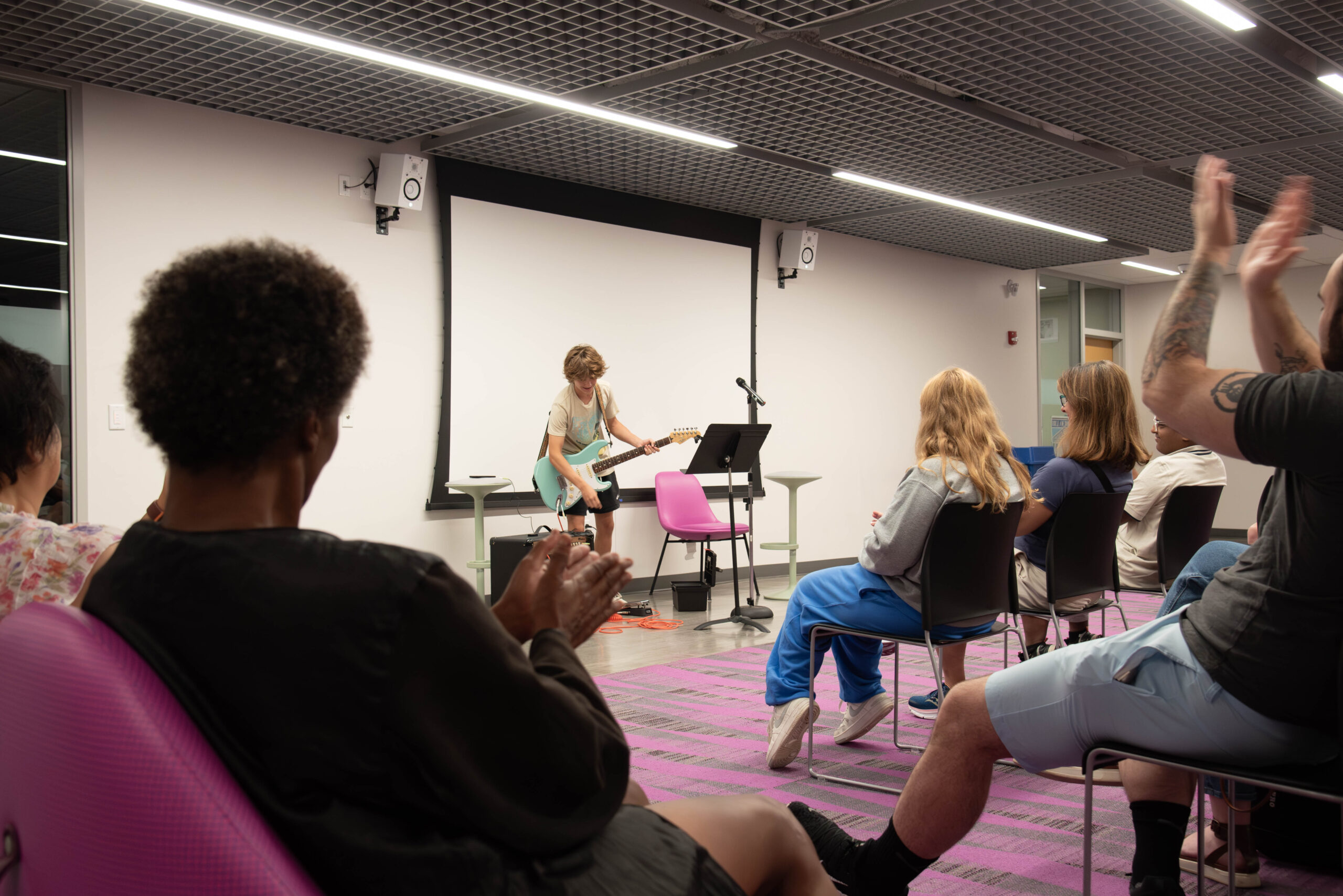 Audience applauds a guitar-playing teen at Columbia Pike Library's Open Mic Night