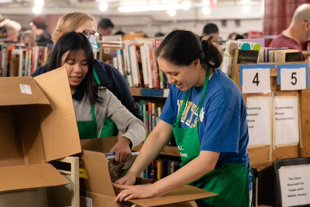 Volunteers restock books from boxes at the Friends of the Arlington Public Library Book Sale