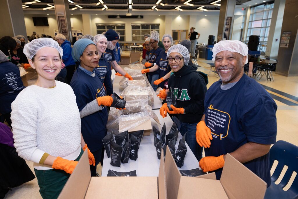 Volunteers smile while packing beans and rice meals during Volunteer Arlington's Annual MLK Day of Service.