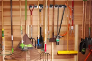 Photo of the inside of the garden tool lennding library's shed, with tools hanging on the back wall.