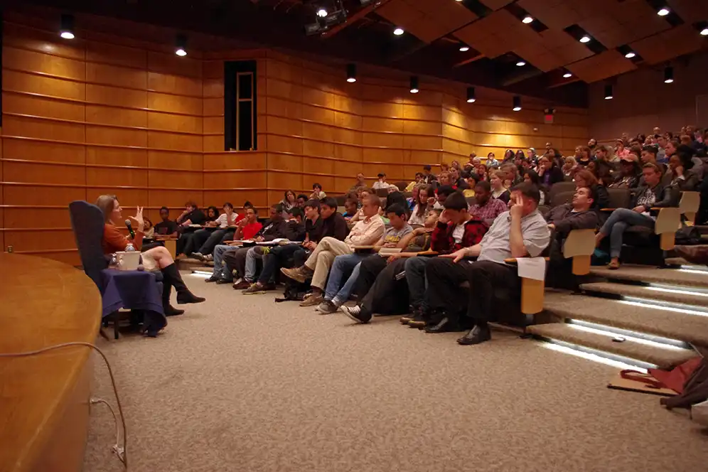 Jennifer Egan sits in an armchair addressing students and faculty in a Marymount University auditorium in 2012.