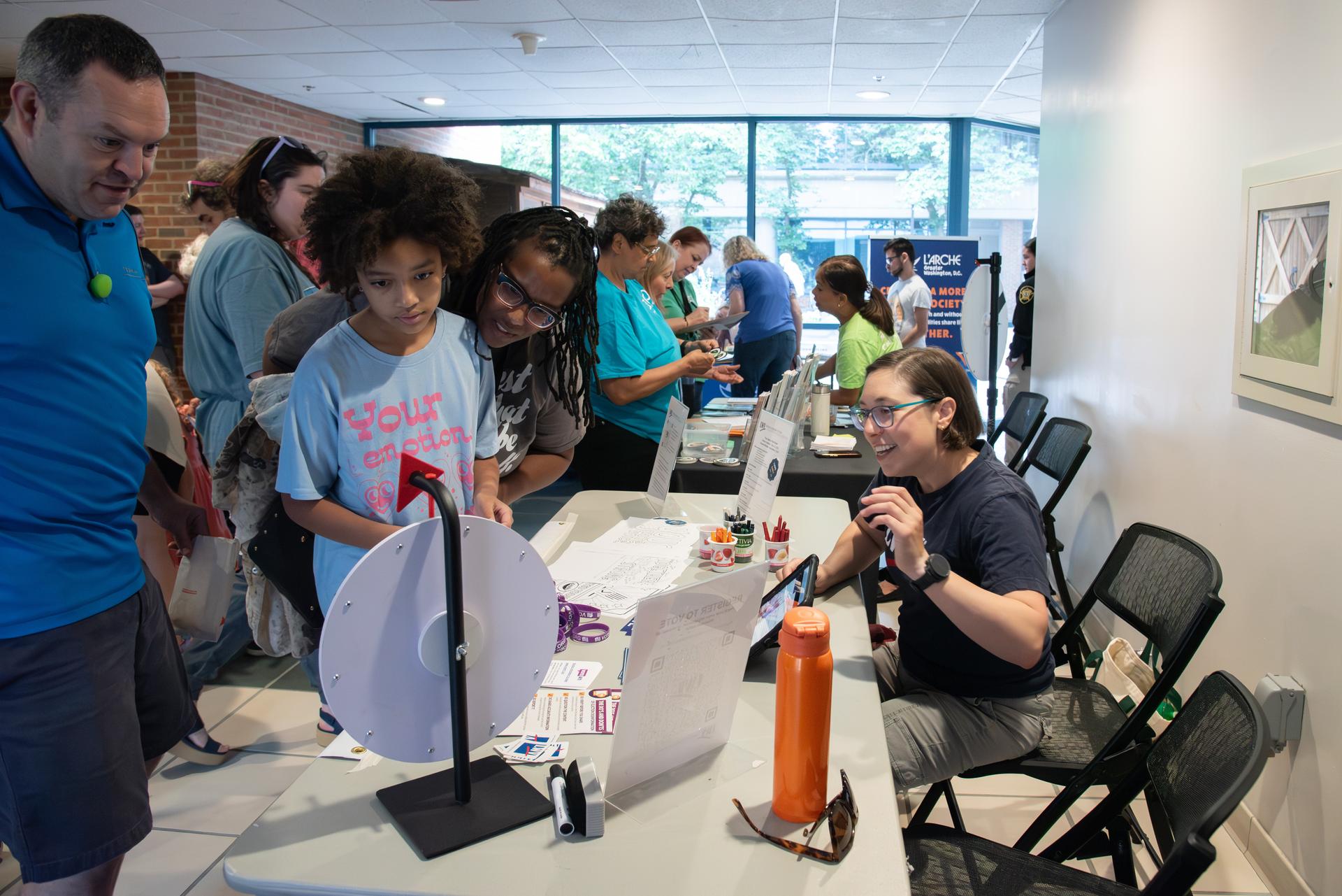 Patrons visit a table at the Community Picnic and Joining Fair.