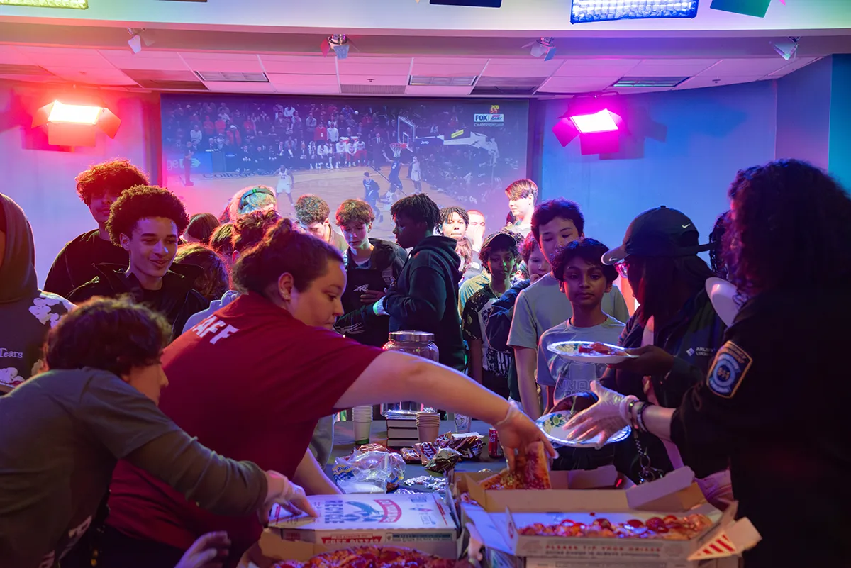 Teen Takeover at Central Library. Teens eating pizza in auditorium.