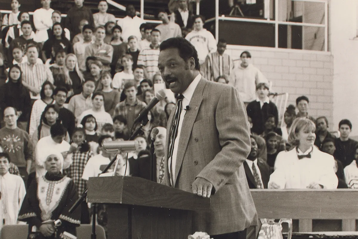 Jesse Jackson speaking at a podium Washington-Lee High School.