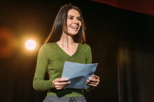 A woman performs poetry or spoken word on a stage.