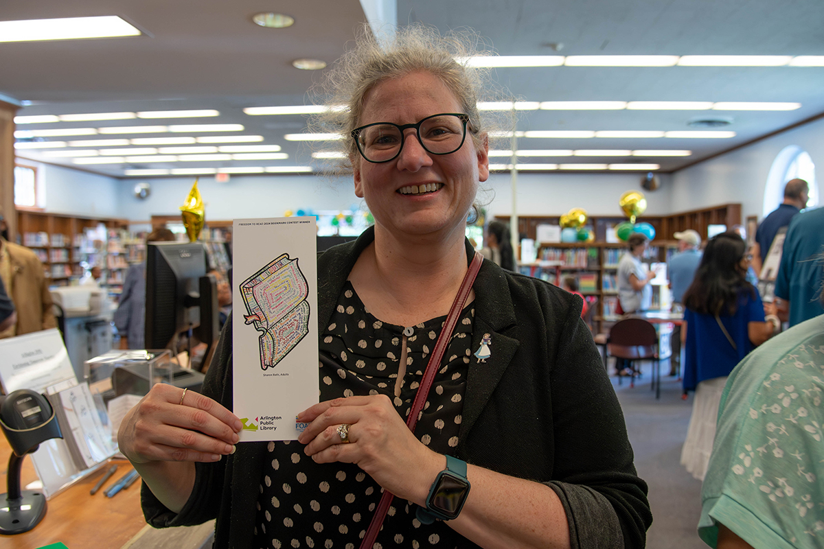 A winning artist of 2024's Freedom to Read Bookmark Contest poses with their printed bookmark.