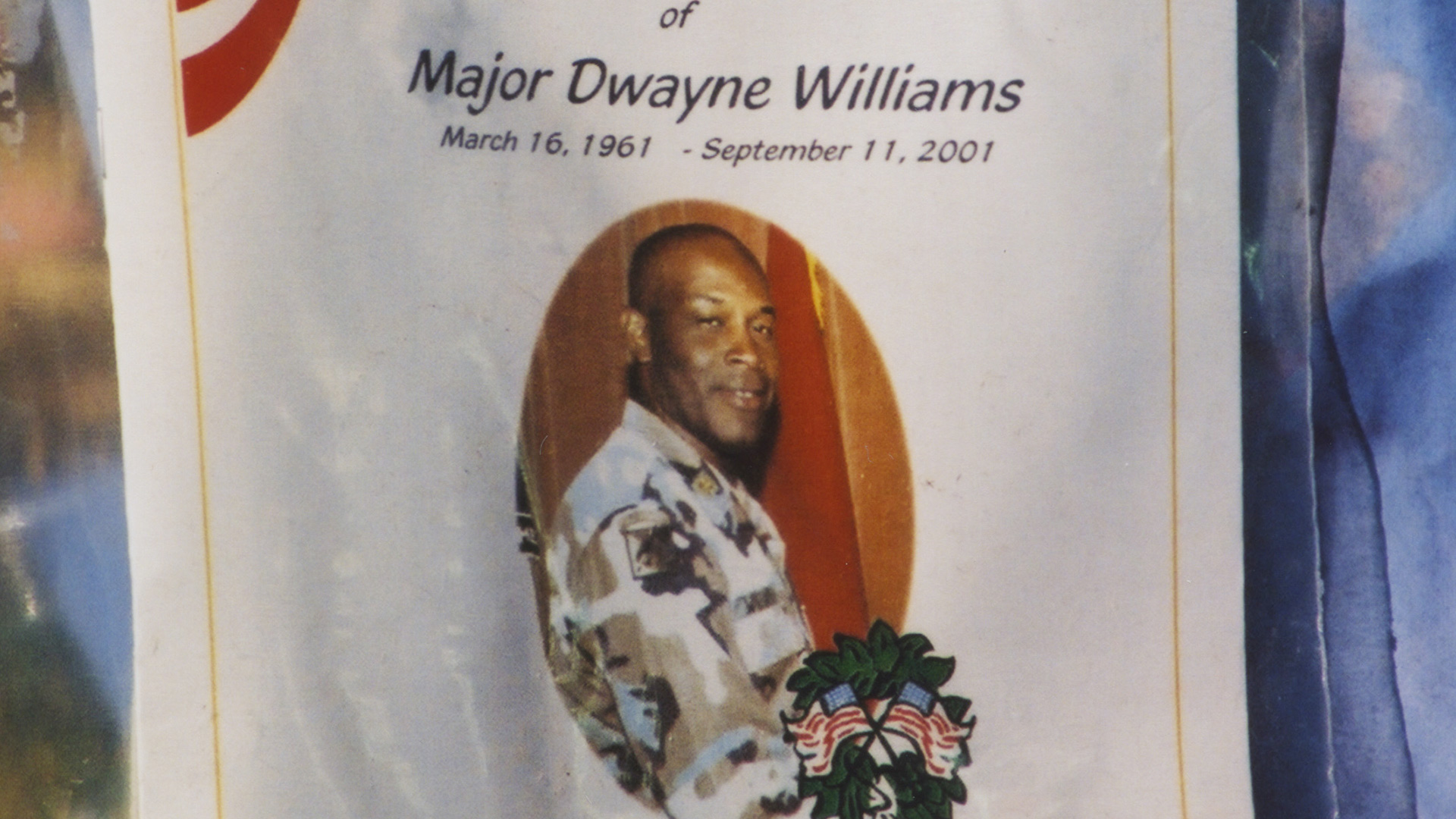 Closeup of a flier for a memorial service for Major Dwayne Williams to be held at Ebenezer African Methodist Episcopal Church in Fort Washington, Maryland on September 28, 2001. The flier is among other items in a large memorial for victims near the grounds of the Pentagon where Williams perished in the 9/11 terrorist attack. Photo credit Diane Kresh. Charlie Clark Center for Local History, 133-01-02-01-127
