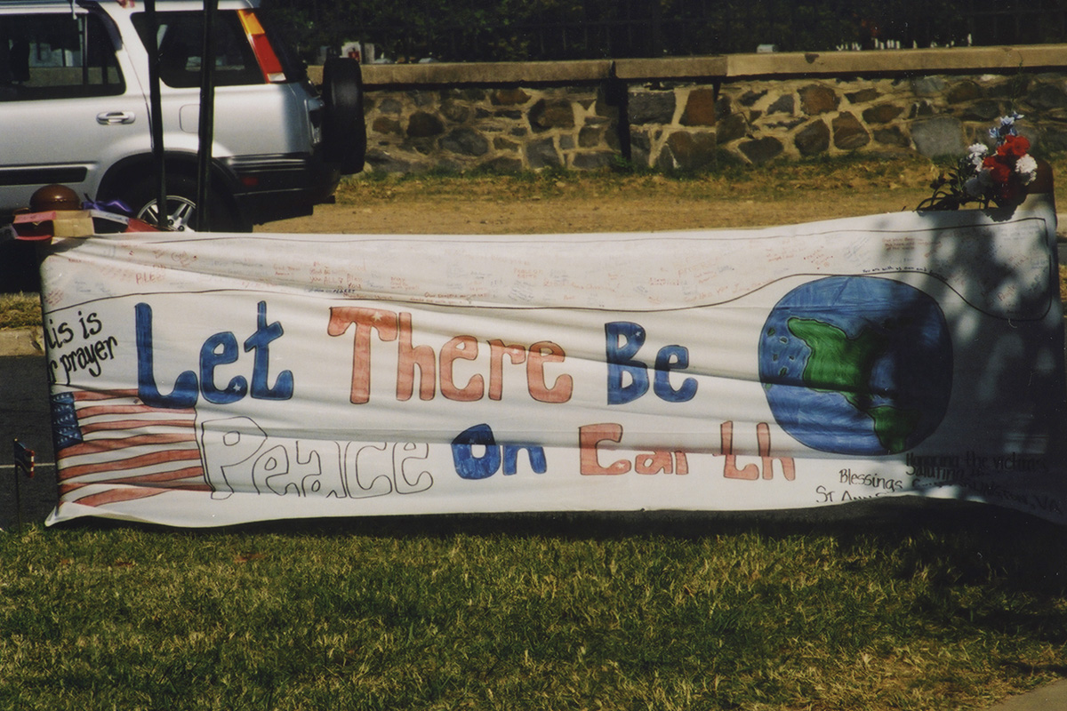 Large banner that reads, “Let there Be Peace on Earth” displayed near the Pentagon following the 9/11 terrorist attacks. Photo credit Diane Kresh. Charlie Clark Center for Local History, 133-01-02-01-130