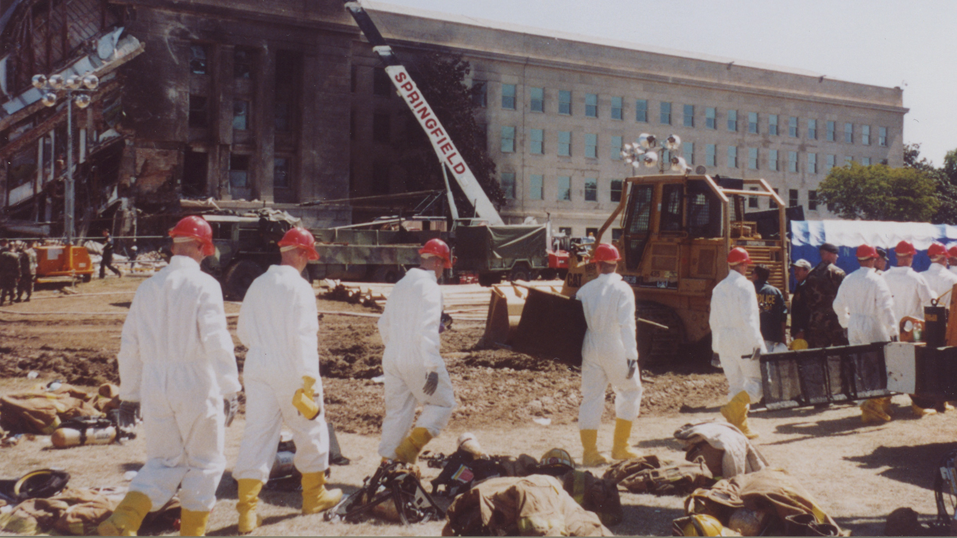 Workers in white suites headed toward the wreckage of the Pentagon the day after the 9/11 attack. Photo credit Michael Defina. Charlie Clark Center for Local History, 133-0066