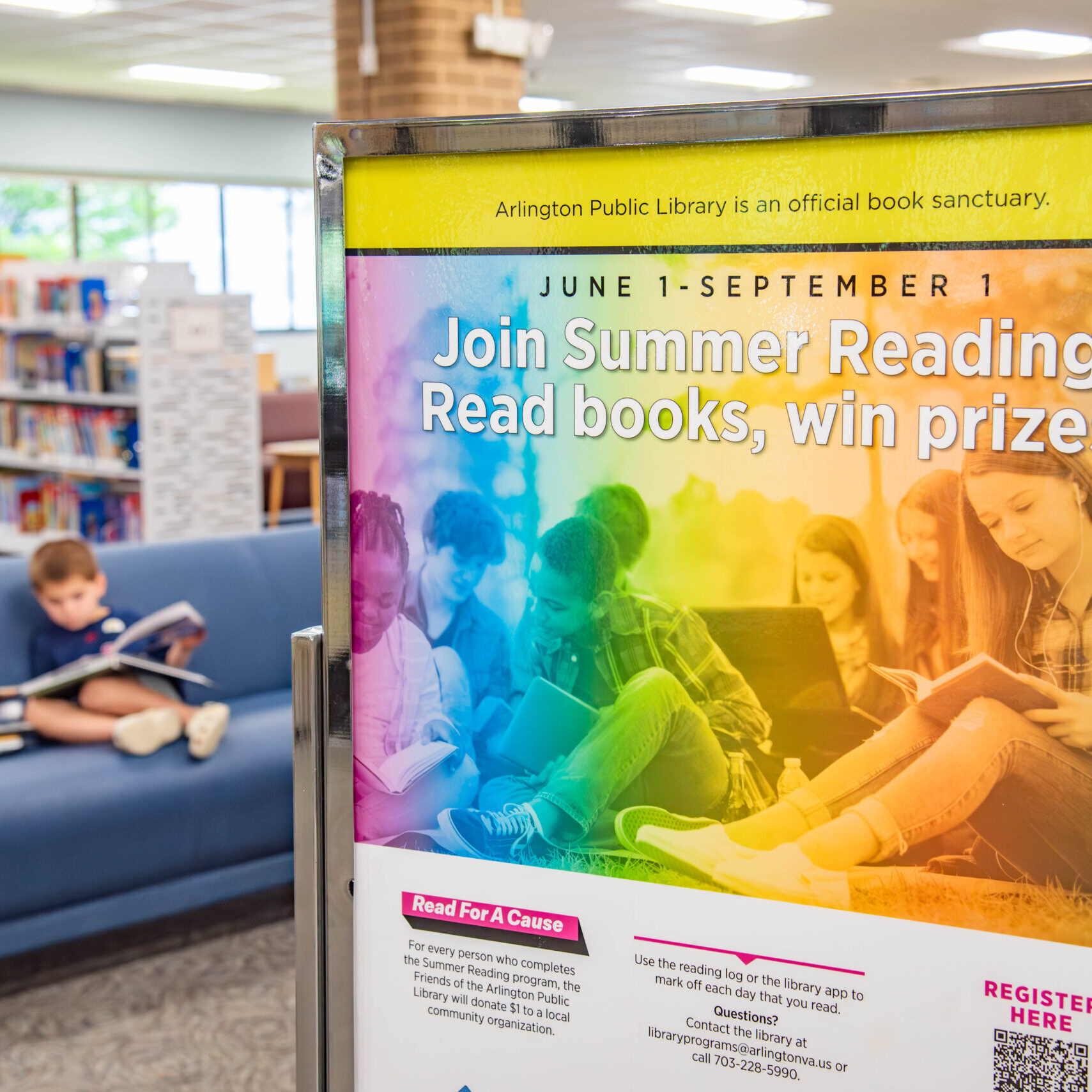 A library poster with text "Join Summer Reading. Read books, win prizes." and a child reading in the background.