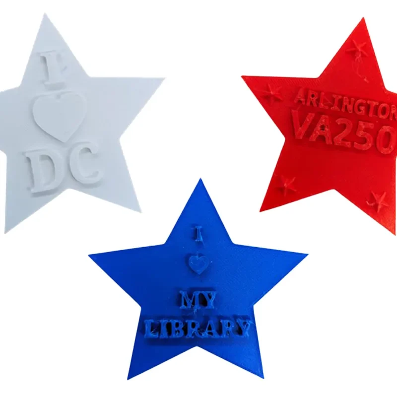 White, blue, and red 3D printed stars with text reading "I heart DC," "I heart my library," and "Arlington VA 250"
