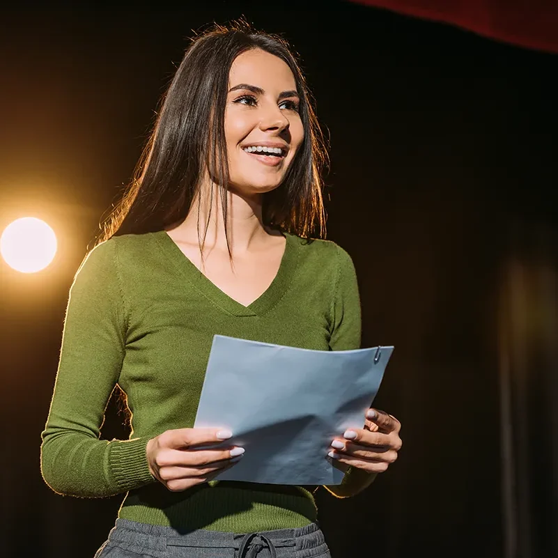 A woman performs poetry or spoken word on a stage.