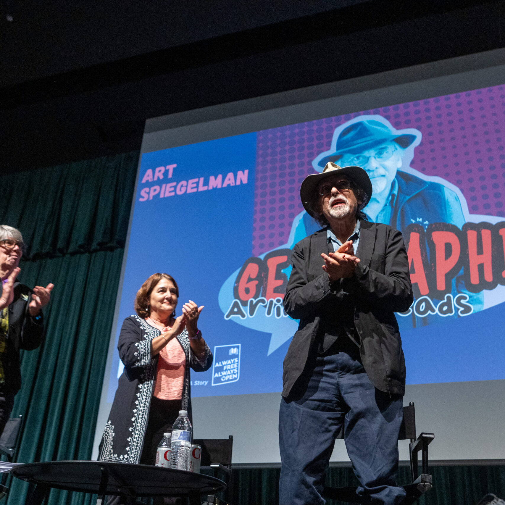 Diane Kresh, Anita Friedman, and Art Spiegelman applaud at an Arlington Reads event.