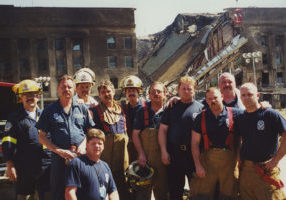 Firefighters stand in front of the burned and broken Pentagon.