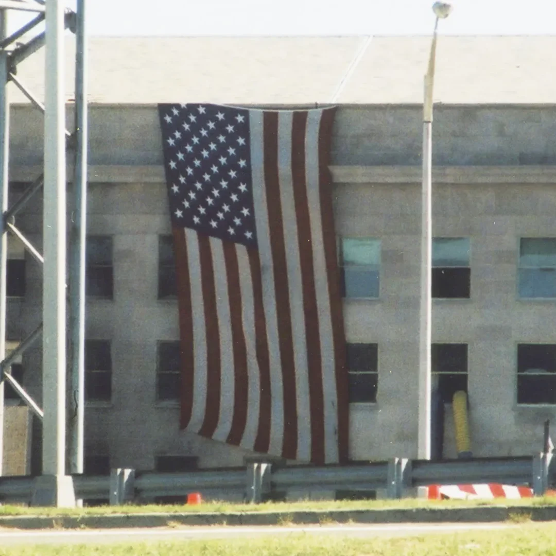 An American flag is draped over a portion of the Pentagon near where the structure was hit by a plane during the 9/11 attack. Photo credit Diane Kresh. Charlie Clark center for Local History, 133-01-02-01-107